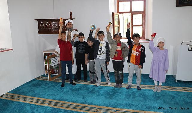 Köy imamı camiye gelen çocuklara ikramda bulunup birlikte oyun oynuyor