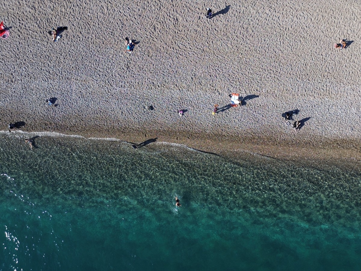 Antalya'da güneşli havayı değerlendirmek isteyen turistler ve kent sakinleri, sahillerde...